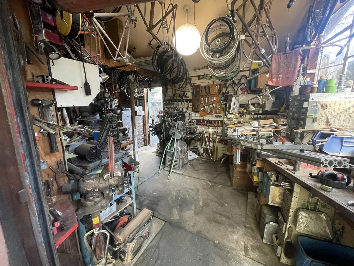Atelier garage d'un framebuilder avec outillage accumulé sur des décennies